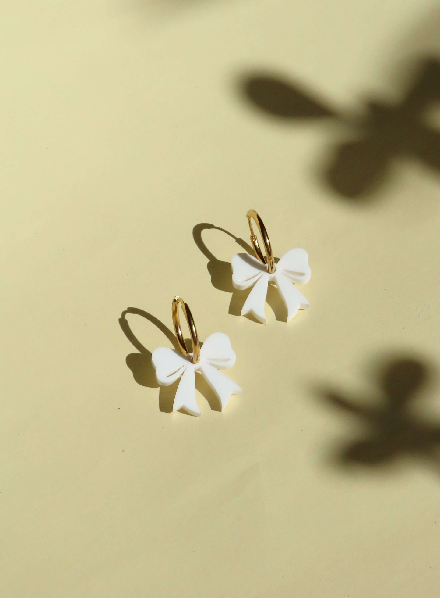 Goldene Creolen mit weißen Schleifen – verspielte Ohrringe mit 3D-Effekt